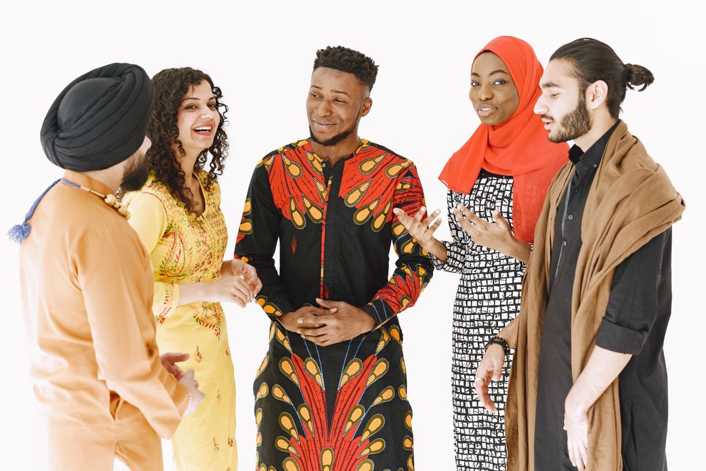 Multicultural group of adults in traditional attire gathered and conversing energetically.